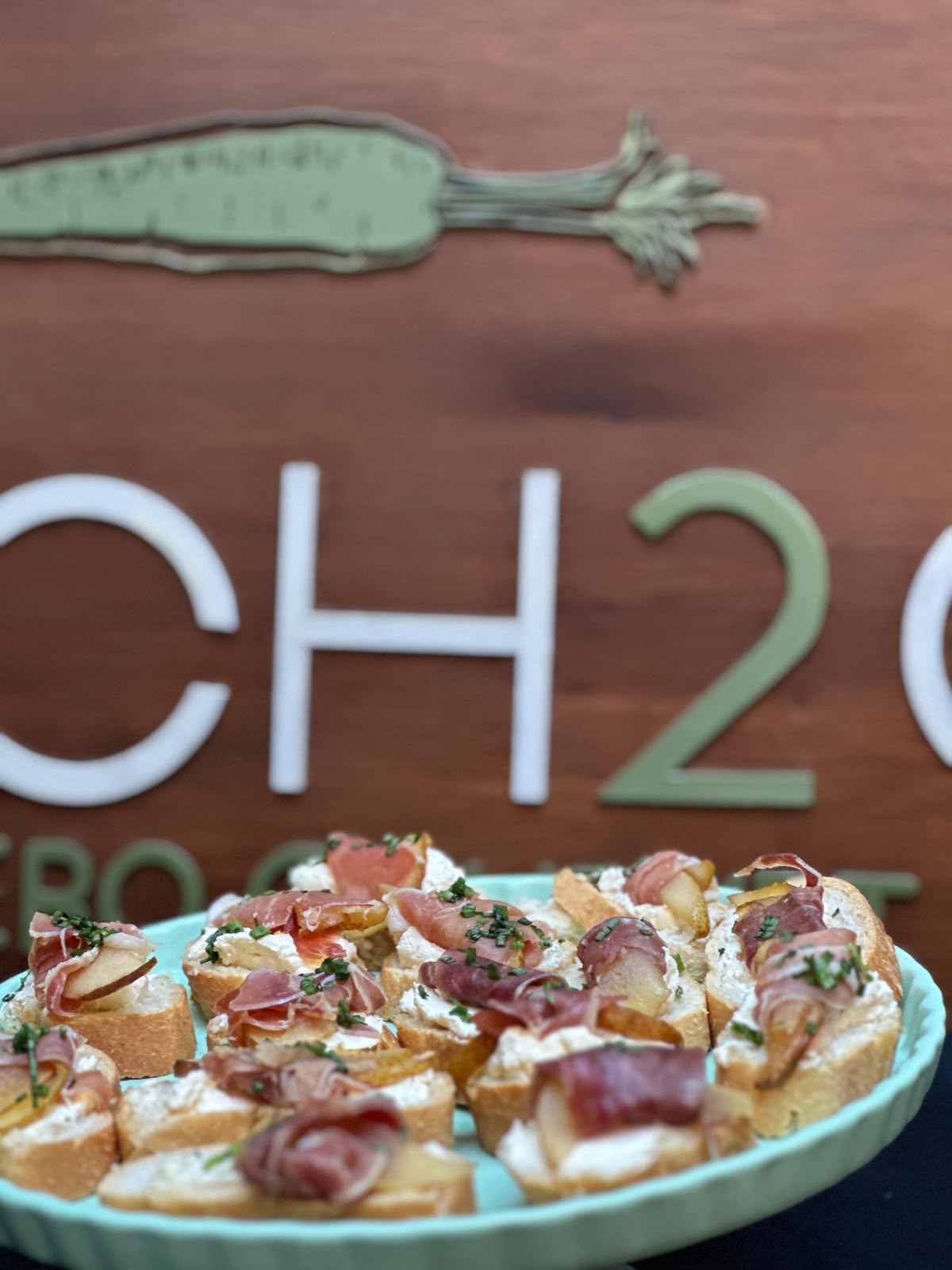 Crostinis de jamón serrano frente al letrero de Lunch 2Go
